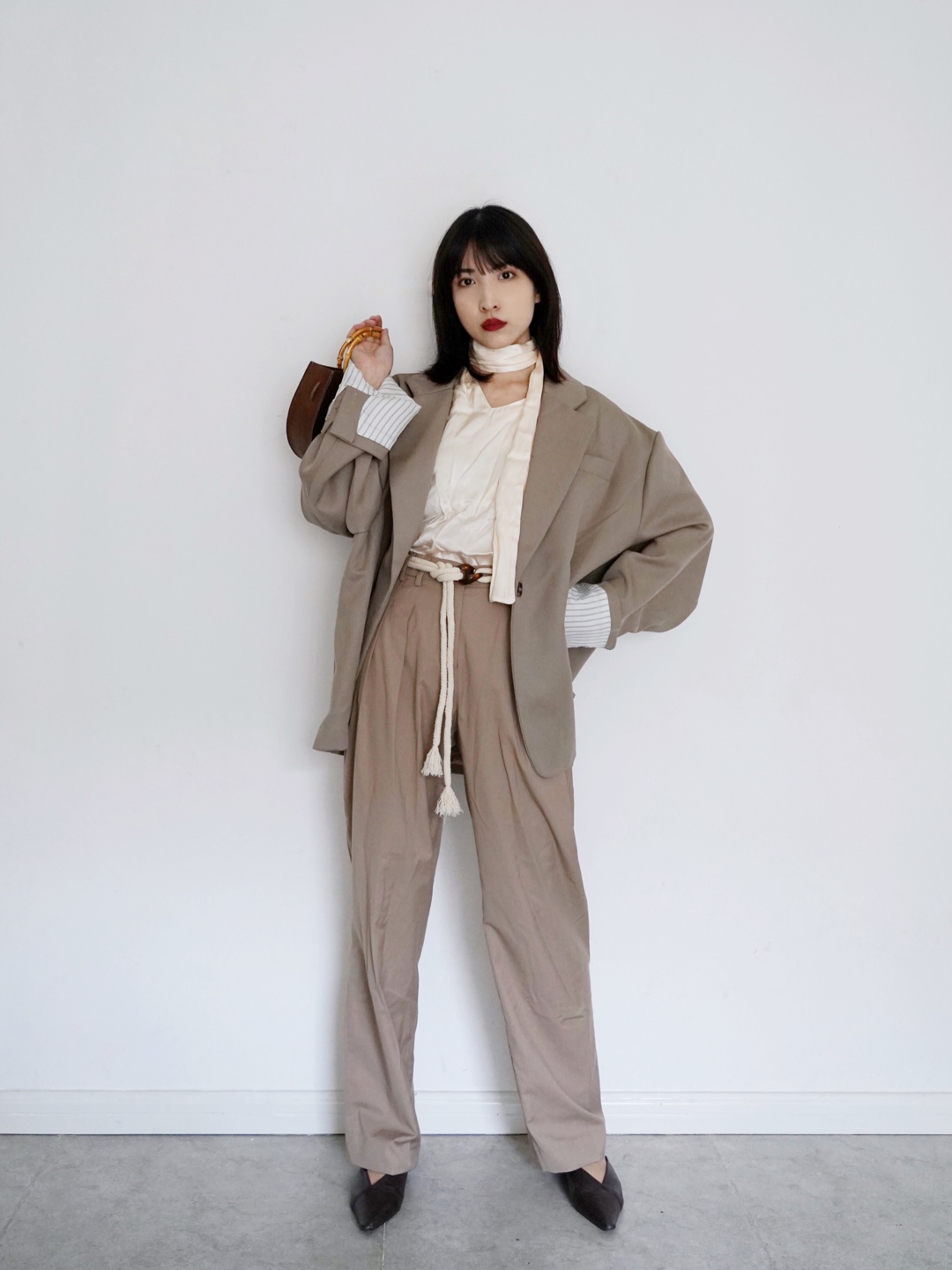 【Valerie’s OOTD】Vol.62
因为我自己有点梨形身材，所以大概有几十条不同质地不同颜色的阔腿裤，一年四季都靠这个神器来显高显瘦。
这一套我穿的是一条中腰的沙石色阔腿裤，莫兰迪色系非常好搭。裤长是可以拖地的那种，比短一截的阔腿裤更显高级。
搭配一个杏色的丝质背心和杏色的腰带，颜色上相呼应。外面再搭配一个同是沙石色系的oversize西装，整套就是帅帅的春季穿搭了。
#解救小粗腿，一招瘦腿裤搞定！#